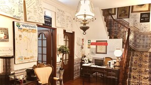 Une pièce comprenant un bureau, une chaise et un escalier orné de balustrades décoratives.