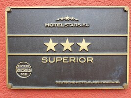Una placa de metal con el texto "HOTELSTARS.EU" y la clasificación "SUPERIOR", junto con el logo "DEUTSCHE HOTELKLASSIFIZIERUNG".