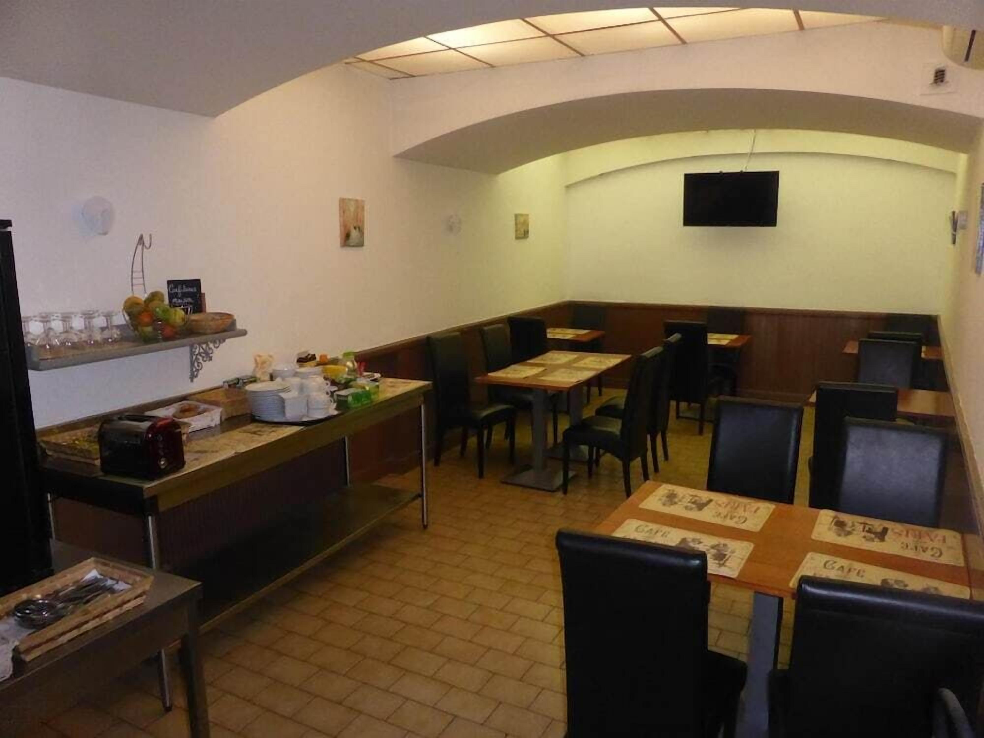 Un restaurante con techo curvo, mesas con menús y sillas.