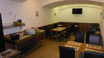 Un restaurante con techo curvo, mesas con menús y sillas.