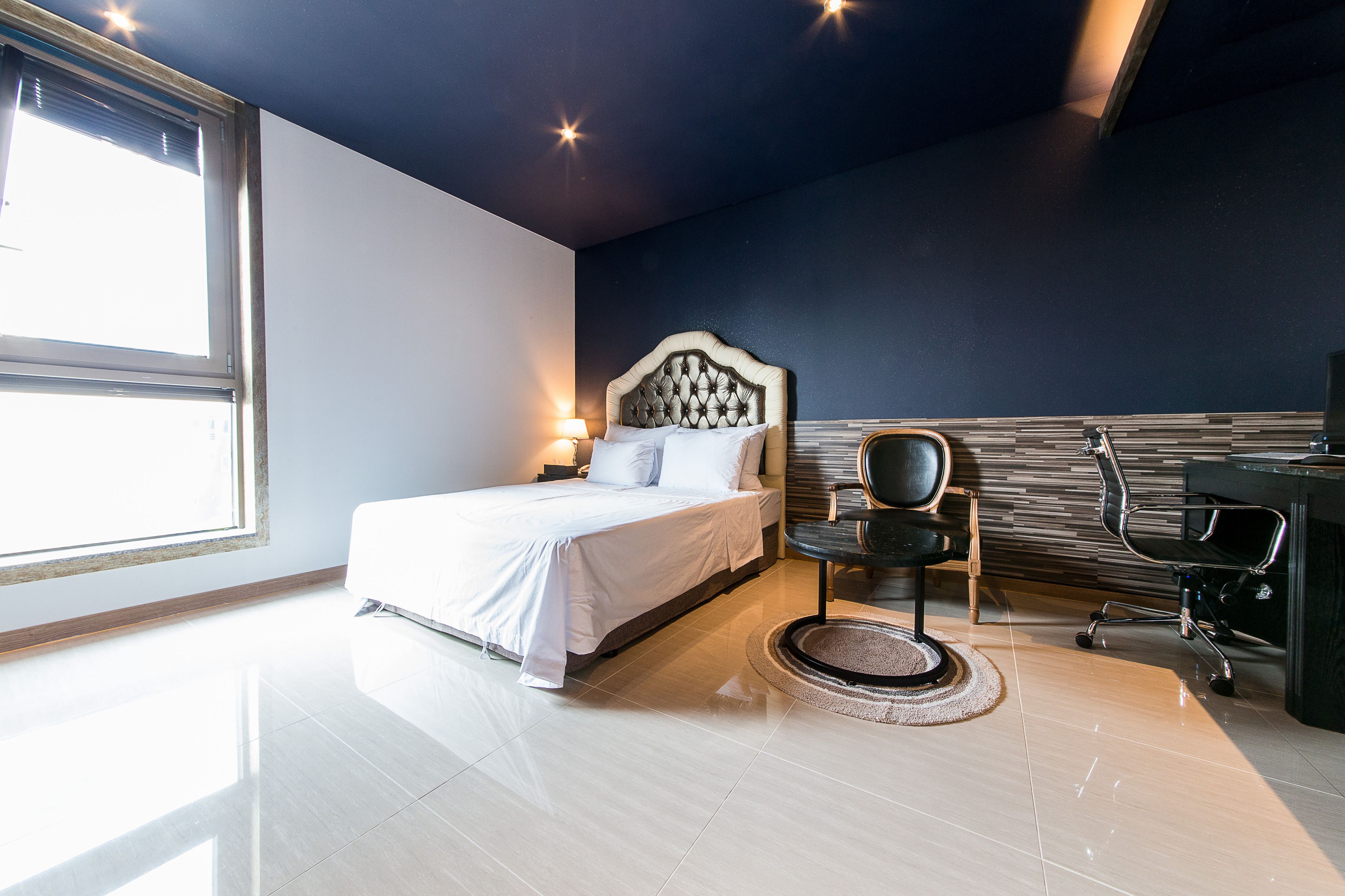 Une chambre à coucher moderne avec un grand lit, un bureau et une chaise.