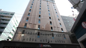 Een hotelgebouw met een moderne gevel, meerdere ramen en een bord waarop 'SB HOTEL' staat.