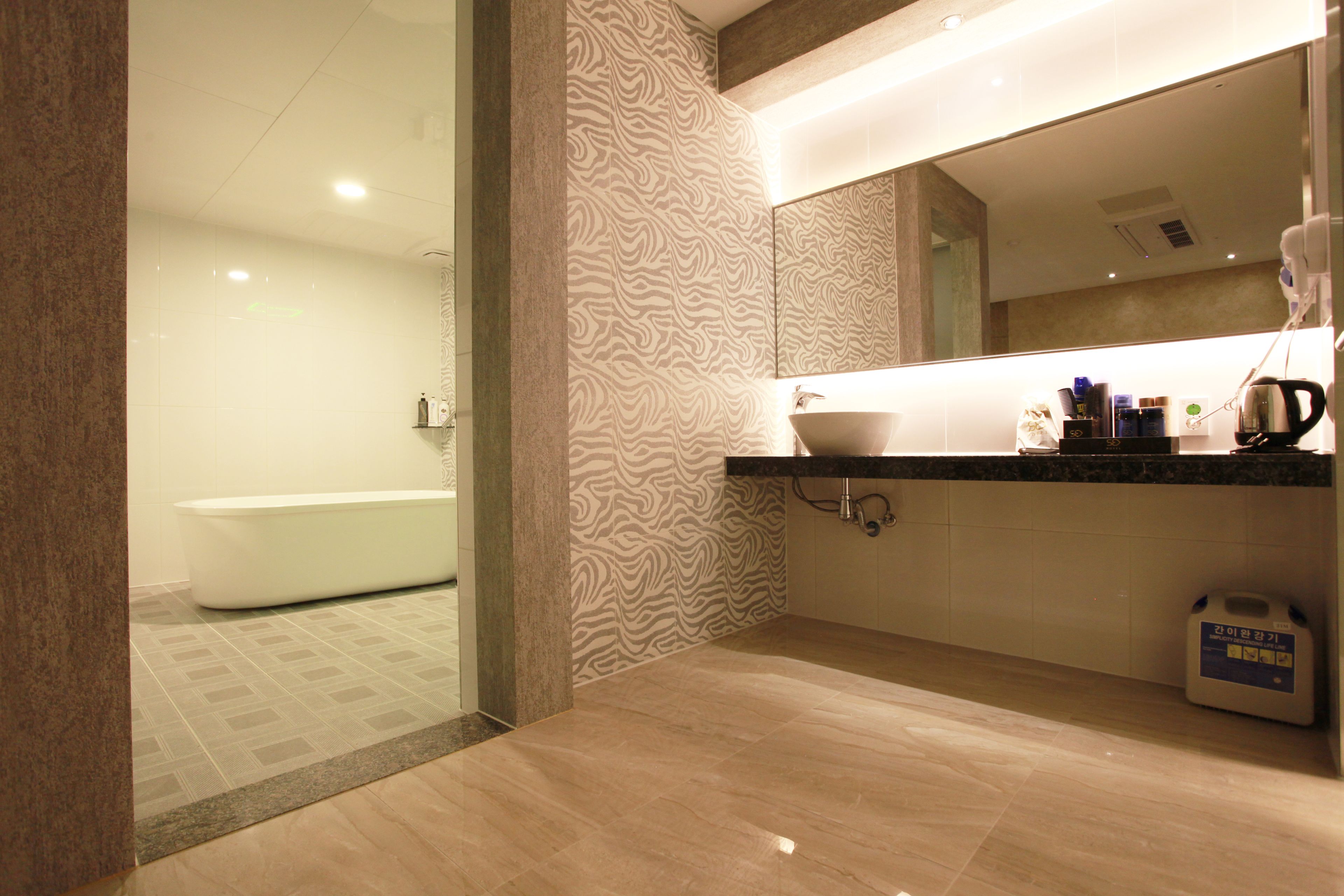 A modern bathroom with a bathtub, a sink, and a mirror.