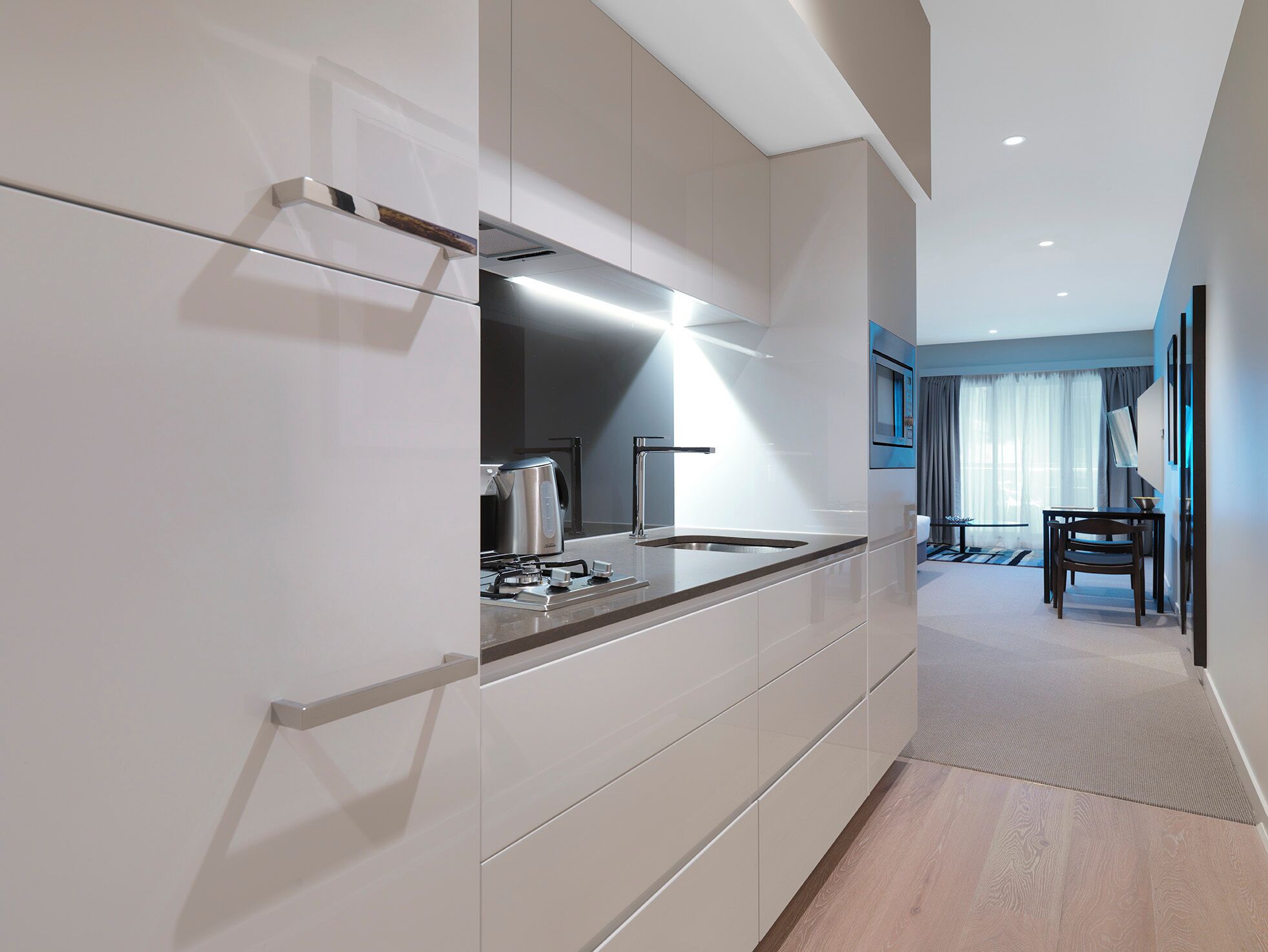 Een moderne keuken met inbouwapparatuur, een eethoek met tafel en stoelen, en uitzicht op de omgeving.