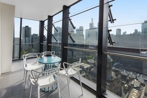 Una habitación moderna con ventanas amplias, una mesa redonda y sillas blancas.