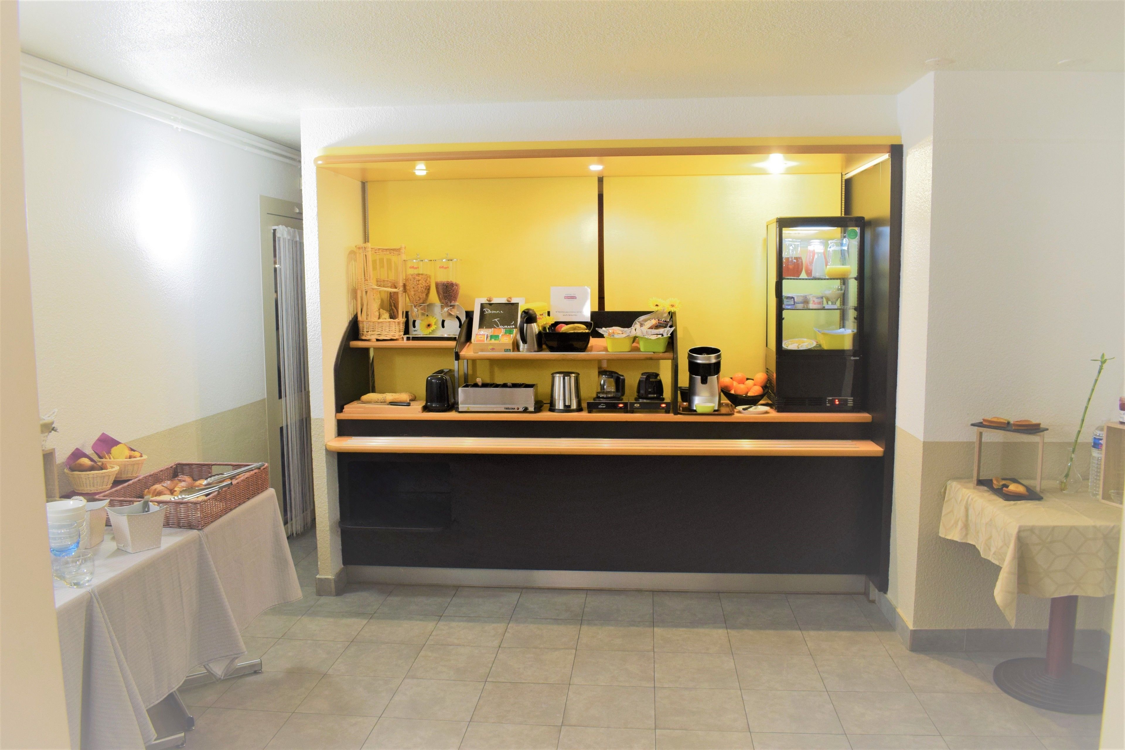 A breakfast bar with a coffee machine, toaster, and various food items.