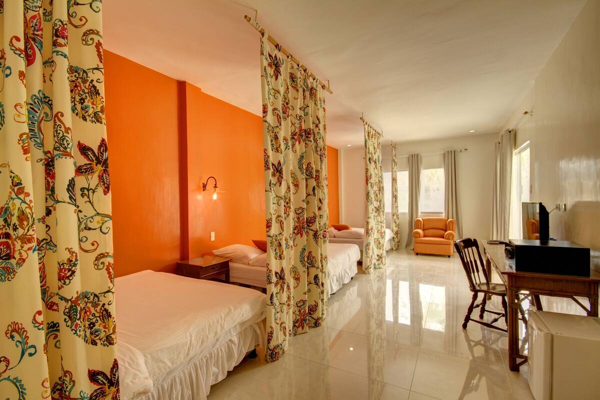 A hotel room with two beds, a desk, and a chair.