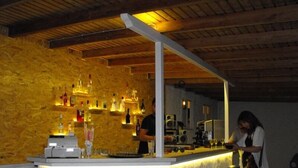 Un'area bar con sgabelli, un bancone e un soffitto in legno.