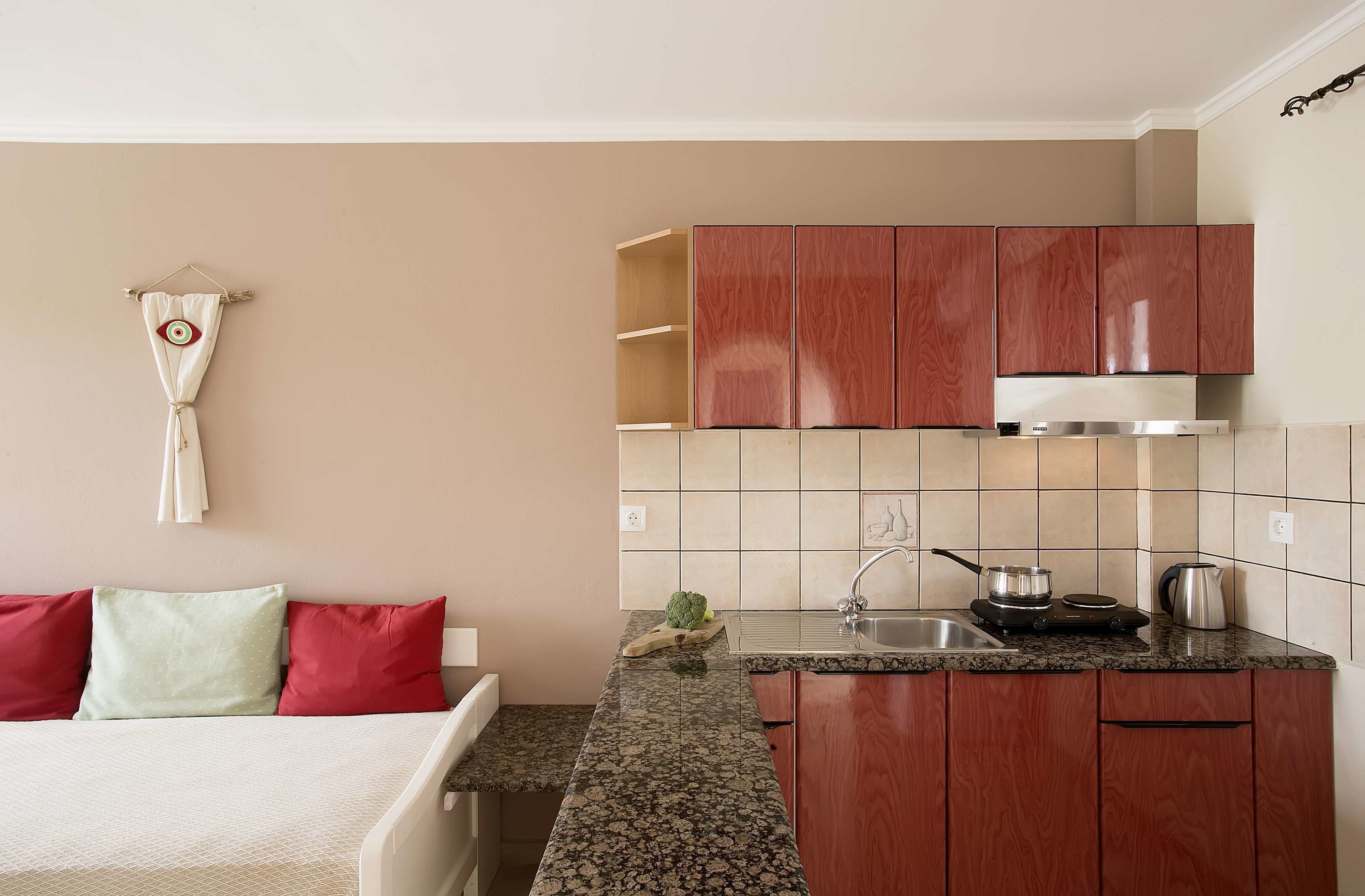 A compact kitchen with wooden cabinets, a granite countertop, and basic appliances.