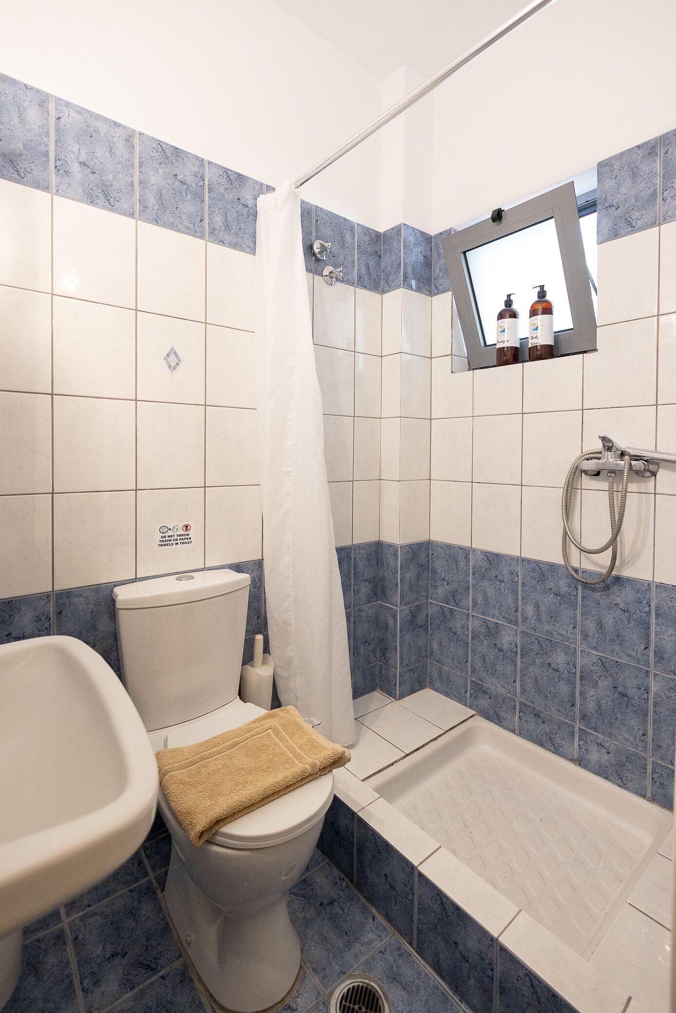 A bathroom with a toilet, sink, and shower.