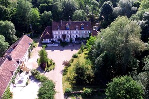An aerial view of a large, multi-story building with a symmetrical facade, surrounded by lush greenery and a spacious courtyard. - Le Moulin du Bas Pesé (Mont-pres-Chambord)