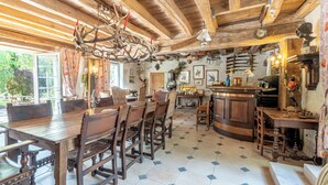 A rustic dining area with wooden furniture, a chandelier, and a tiled floor. - Le Moulin du Bas Pesé (Mont-pres-Chambord)