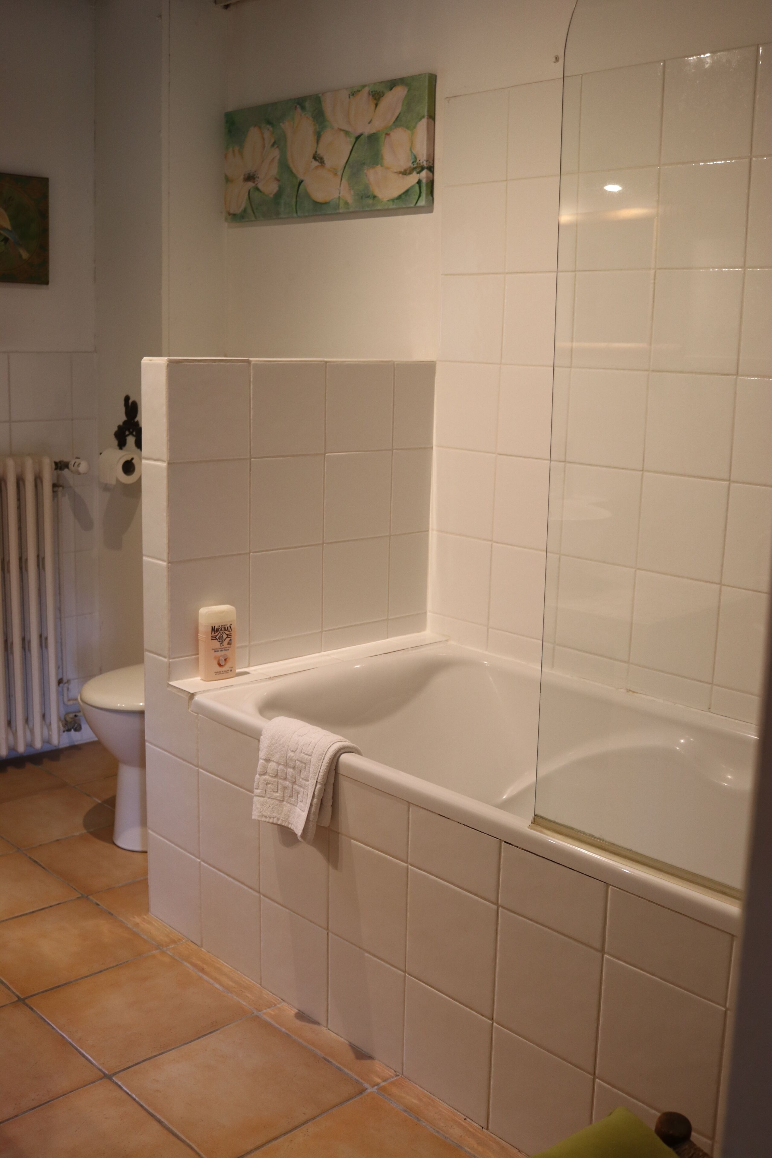 Ein Badezimmer mit Badewanne, Toilette und Duschbereich.