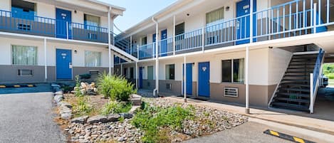 A motel with a central courtyard, multiple balconies, and a staircase leading to the upper floors.