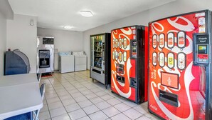 Ein Zimmer mit Getränkeautomaten, Wasserspender, Mikrowelle und Kühlschrank.