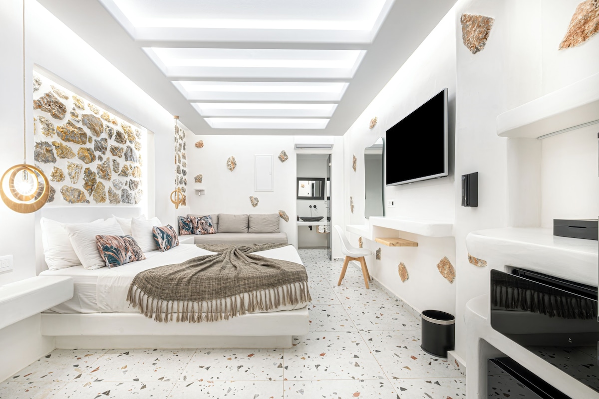 Ein modernes Schlafzimmer mit Bett, Sofa, Fernseher und Klavier.