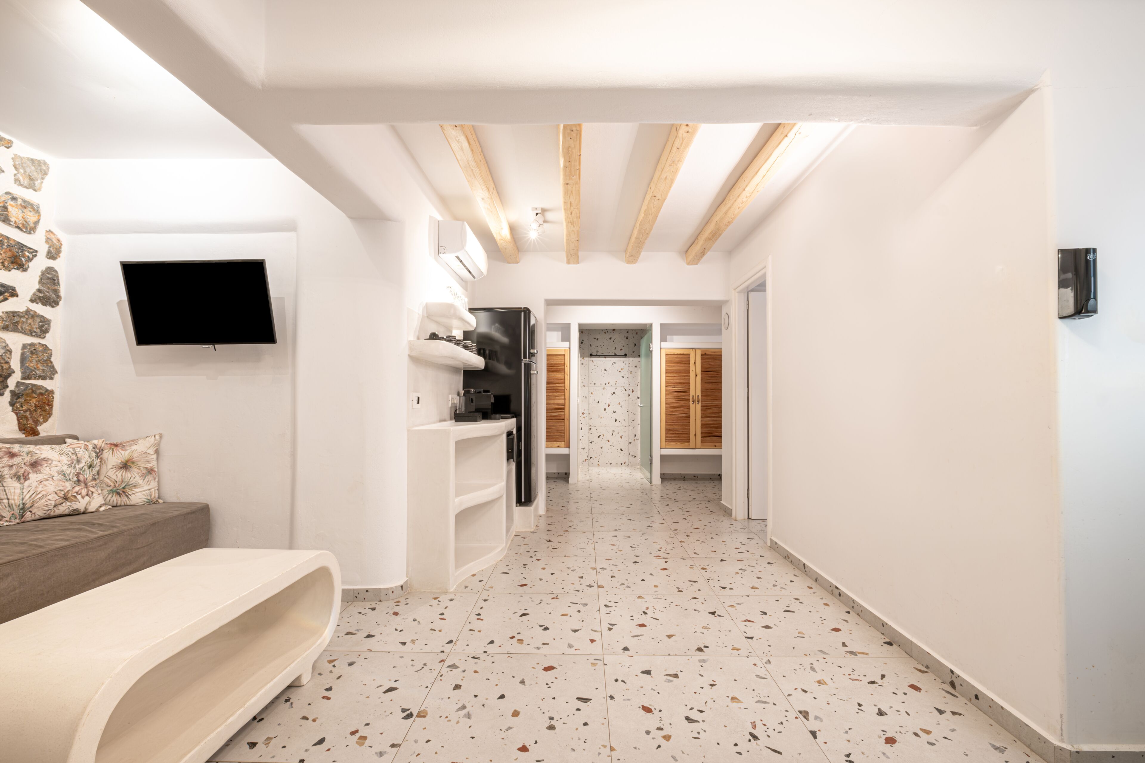 Een modern interieur met een keuken, zithoek en een gang naar een badkamer.