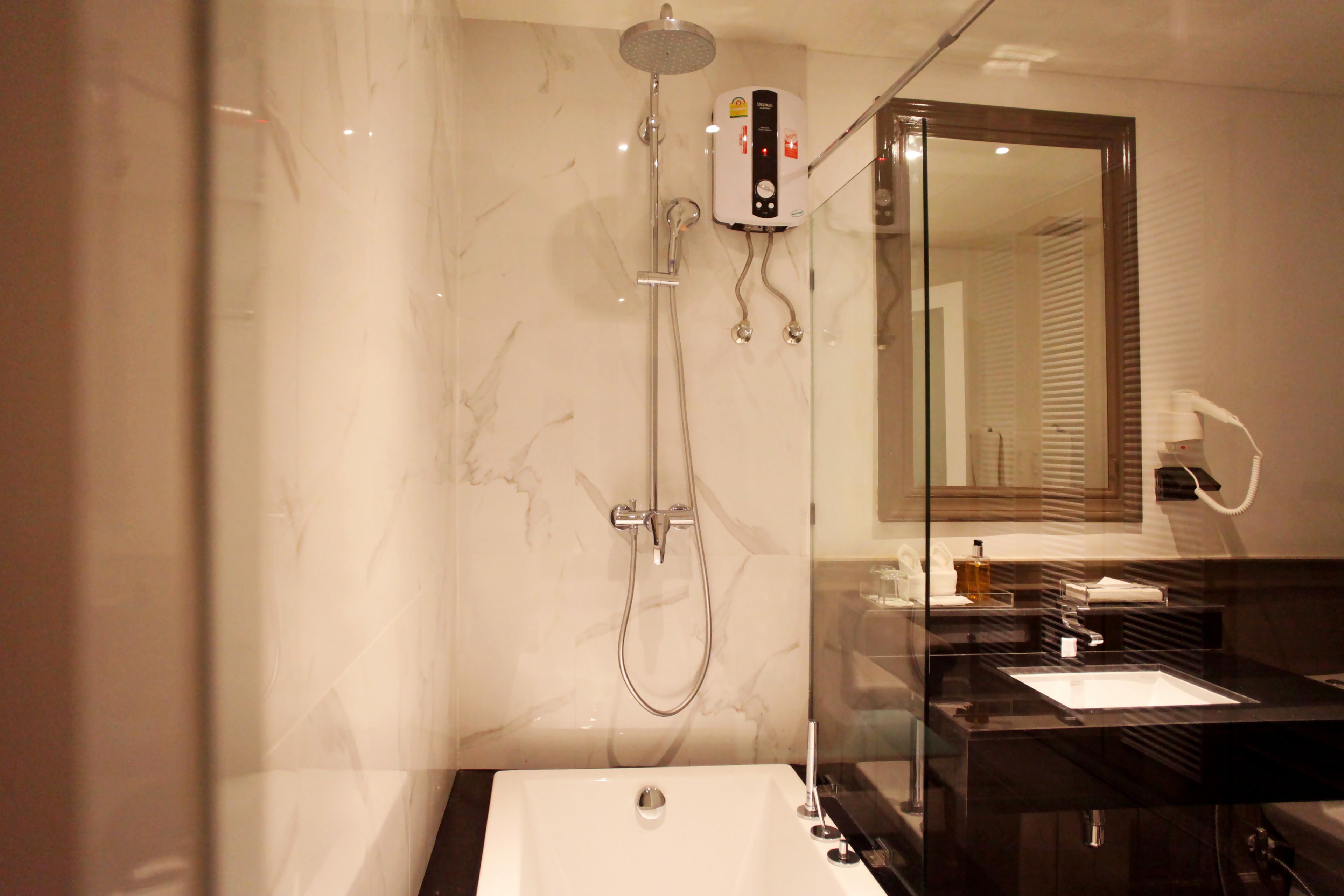 A modern bathroom with a glass-enclosed shower, a white bathtub, and a black vanity with a mirror.