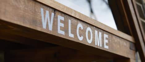 A wooden sign with the word "WELCOME" in white letters.