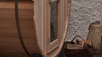 A wooden barrel-shaped window with a door, a wooden bench, and a wicker basket on the ground.