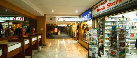 Une librairie avec une enseigne indiquant une collection de livres sur Donjons et Dragons, un sol en marbre et une autre enseigne indiquant qu’il s’agit d’une librairie Newsweek.