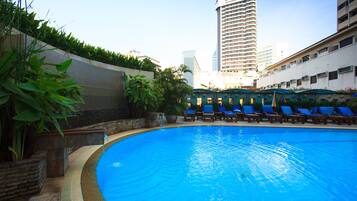 Alberca al aire libre y camastros