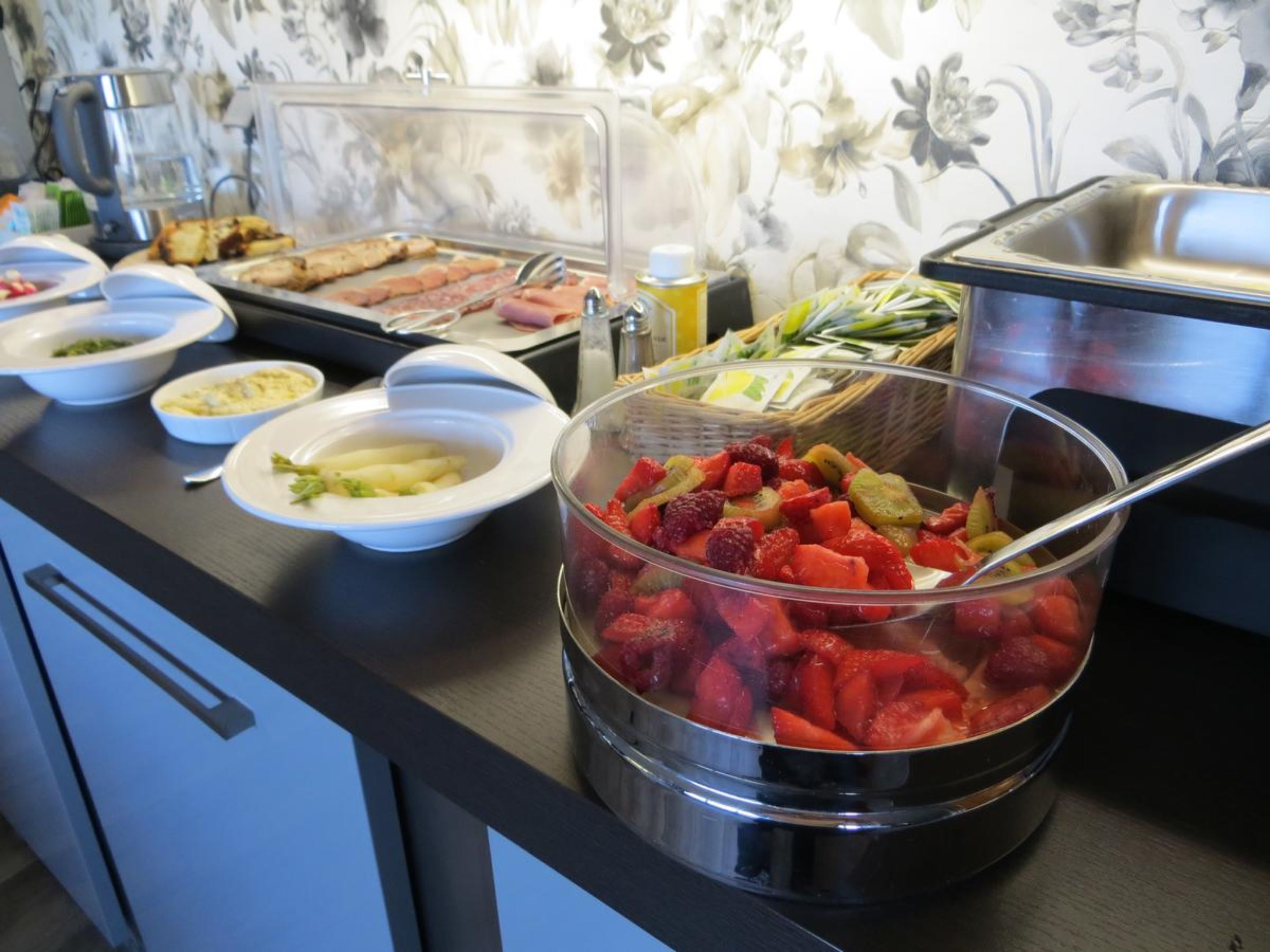 A buffet with various food items including fruits and dishes.