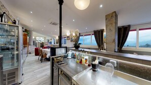 Una cocina moderna con barra, un ventanal con vistas y una zona de comedor con un sofá rojo.
