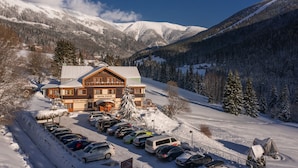 A hotel with a ski lift, surrounded by snow-covered mountains and trees. - Hotel Zátiší (Spindleruv Mlyn)