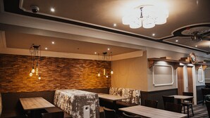 Un interno ristorante caratterizzato da pareti in legno, lampade a sospensione e pavimento a scacchi.