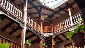 A multi-level wooden balcony with stone walls and potted plants. - Hosteria Durán (Banos)