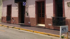 Un edifici rosat amb un cartell que indica que és un hotel.