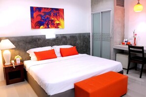 A hotel room with a bed, a desk, a chair, a lamp, and a painting on the wall. - 7days Hotel Patan (Chiang Mai)