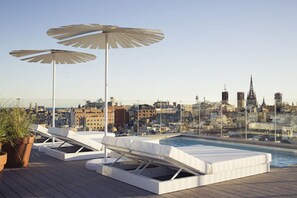 Een buitenzwembad, parasols voor strand/zwembad