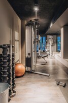 A gym with exercise equipment, a large exercise ball, and dumbbells.