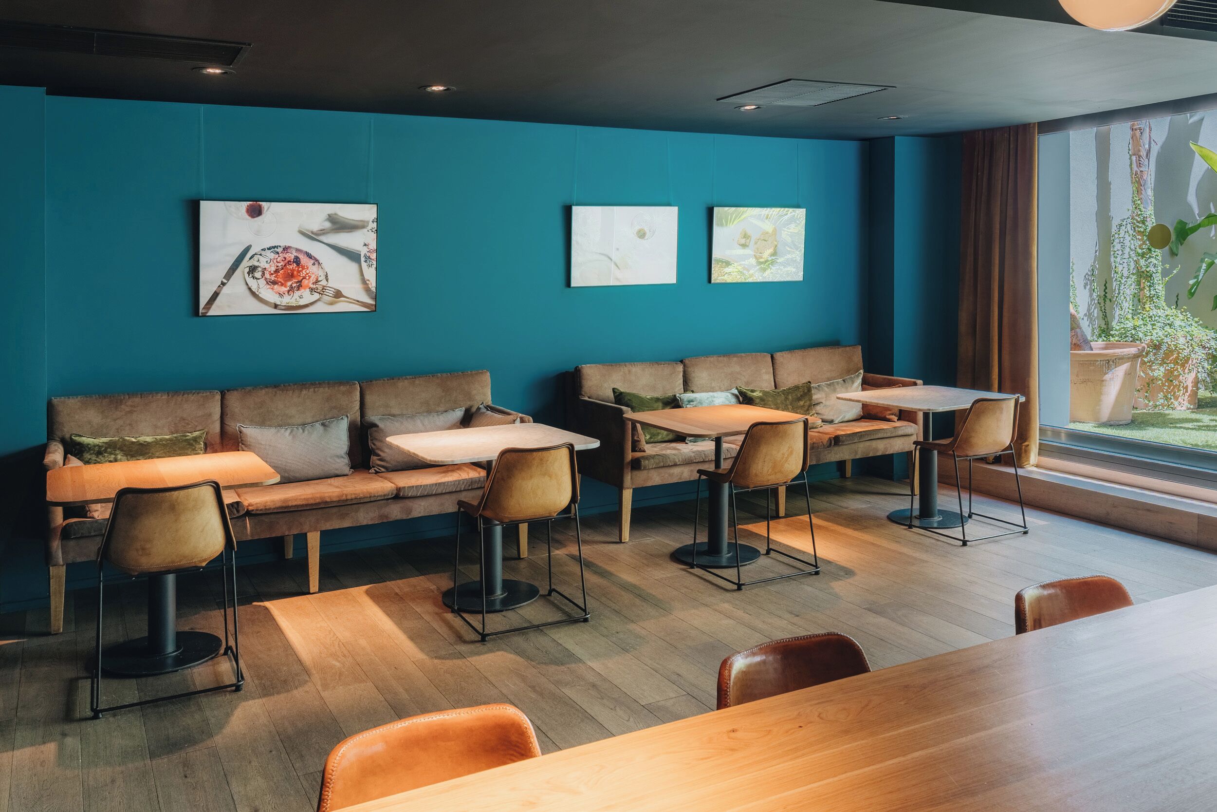 Un interior moderno con una pared color turquesa, muebles de madera y obras de arte.