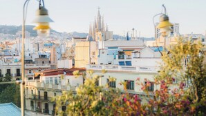 Un balcon offrant une vue sur le paysage urbain, avec notamment un clocher d’église bien visible.