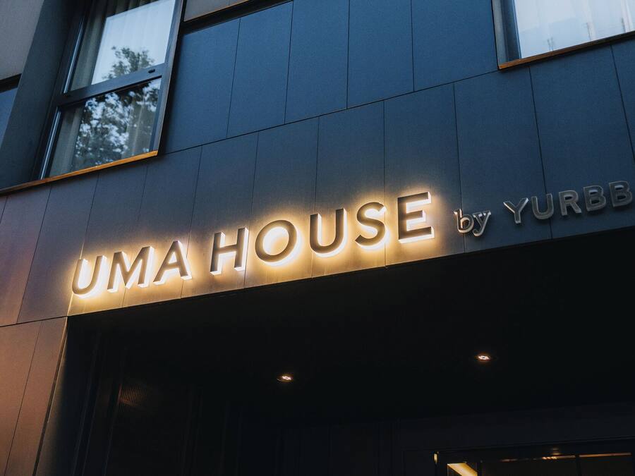 Un edifici amb un cartell que diu 'UMA HOUSE by YURBB'.