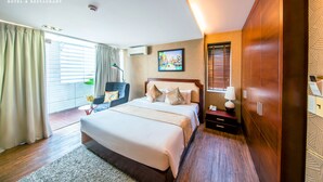 A hotel room with a large bed, a desk, a chair, a wardrobe, and a window with curtains. - Crown Diamond Hotel (Ho Chi Minh City)