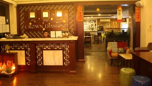 A reception area with a wooden counter, framed pictures, and a sign reading "Crown Diamond". - Crown Diamond Hotel (Ho Chi Minh City)