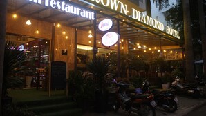 The exterior of the Crown Diamond Hotel with a sign for the Italian restaurant "Alian Restaurant" and a visible menu board. - Crown Diamond Hotel (Ho Chi Minh City)