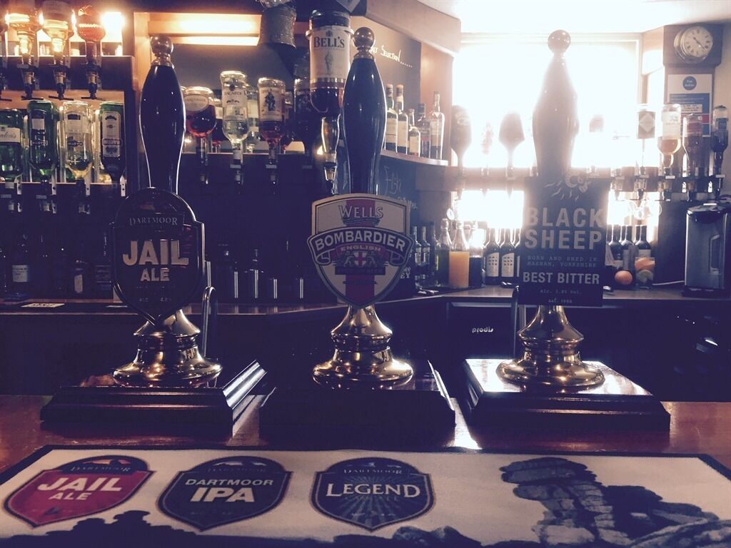 A bar with various beer taps and a selection of liquor bottles.