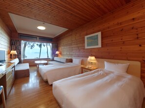 A cabin with two beds, a desk, and a view of the sea. - Okubiwako Makino Grand Park Hotel (Takashima)