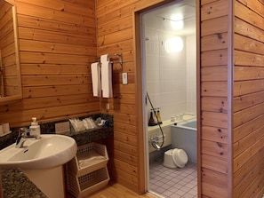 A wooden cabin bathroom with a sink, a mirror, a shower, and a toilet. - Okubiwako Makino Grand Park Hotel (Takashima)