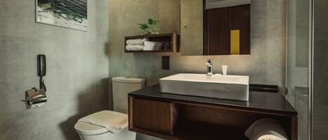 A modern bathroom with a white toilet, a wooden vanity with a sink, and a towel rack.