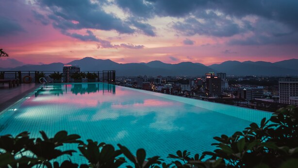 An infinity pool with a cityscape and mountains in the background. - WEIL Hotel (Ipoh)