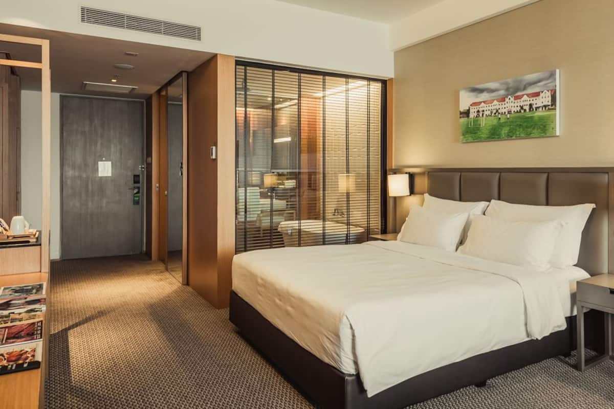 A hotel room with a bed, bedside tables, a wardrobe, and a view through a sliding door.