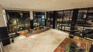 A spacious lobby with a high ceiling, large windows, and a central seating area with a wooden table and chairs. - WEIL Hotel (Ipoh)