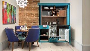A compact kitchen with teal cabinetry, a microwave, a toaster, and a dishwasher.