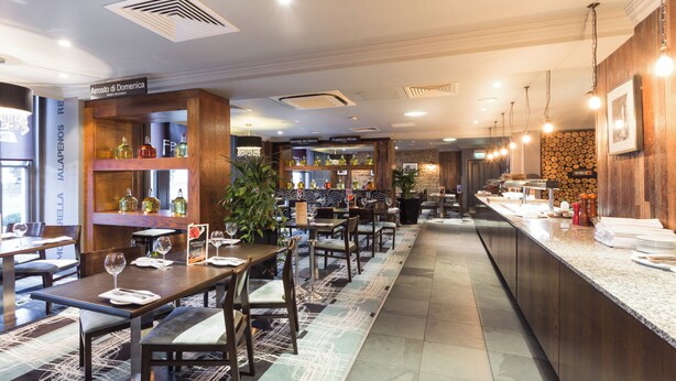 A restaurant with wooden decor, a bar area, and a seating arrangement.
